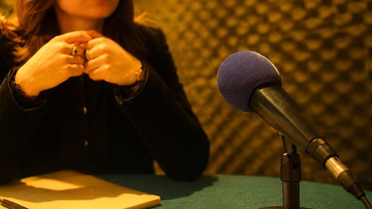 Mikrofon, Hände und Notizen in einer Gesprächssituation